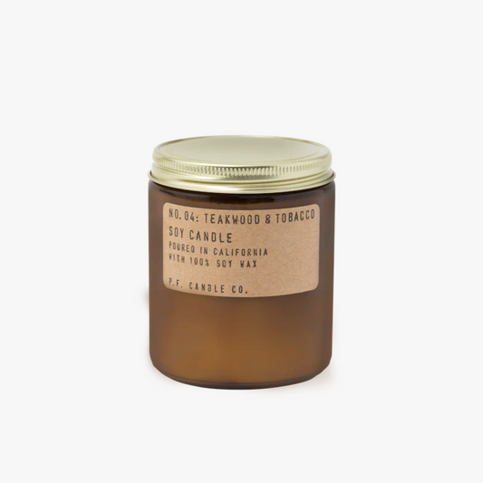 amber glass candle jar with gold lid and brown label that reads No. 04: Teakwood & Tobacco Soy Candle Poured in California with 100% Soy Wax P.F. Candle Co.