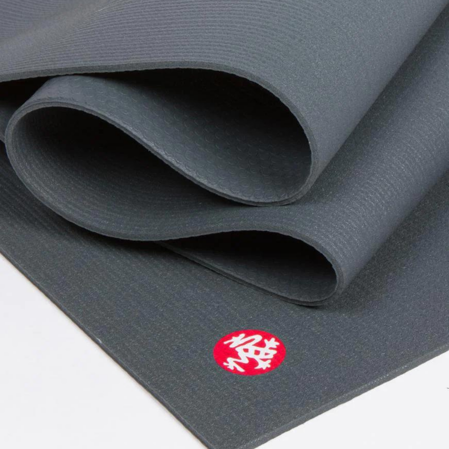 close up of dark grey manduka prolite yoga mat folded over