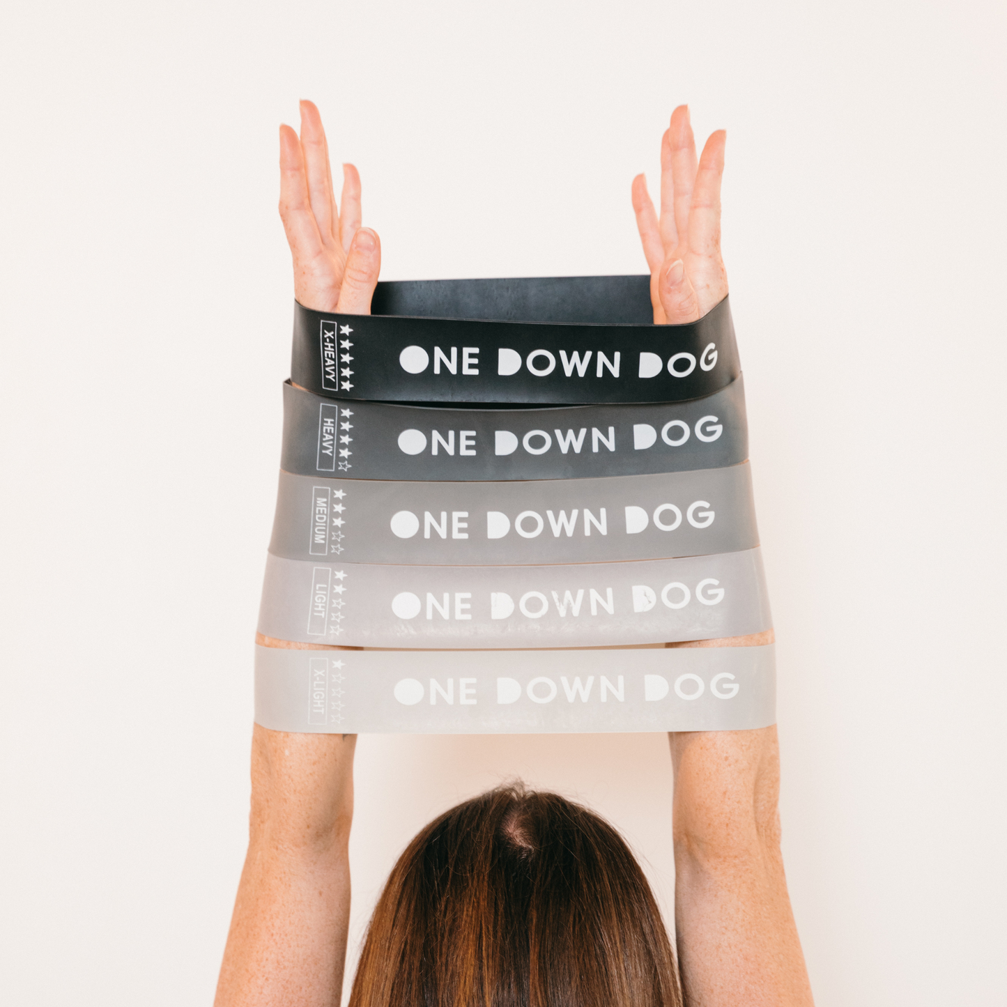 five ombre grey resistance bands stretched out across arms