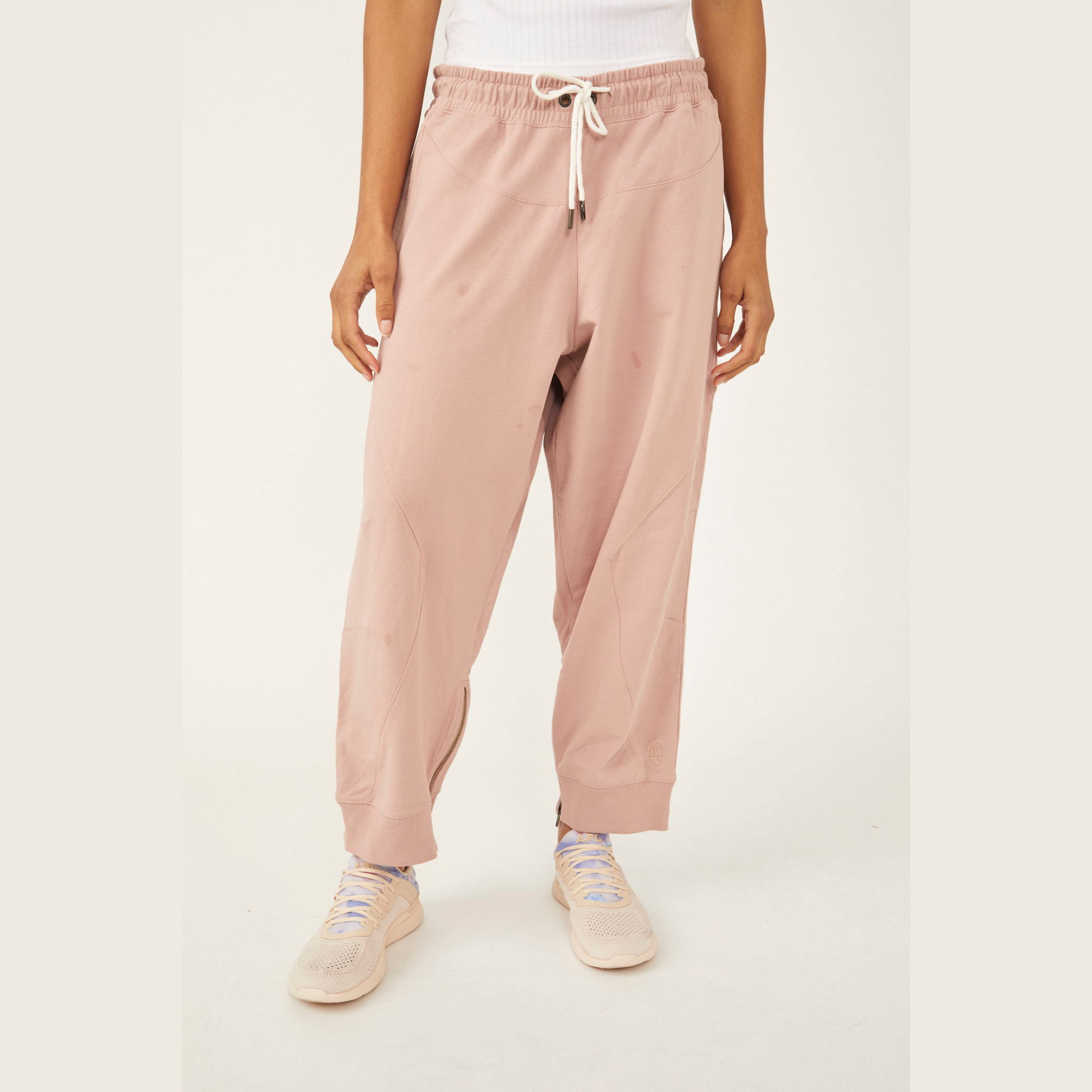 front view of light pink sweatpants with drawstring and zipper at  the ankle 