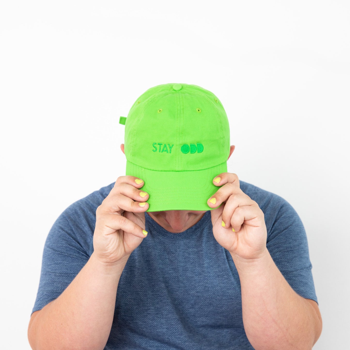Top view of neon green baseball cap with embroidered words STAY ODD