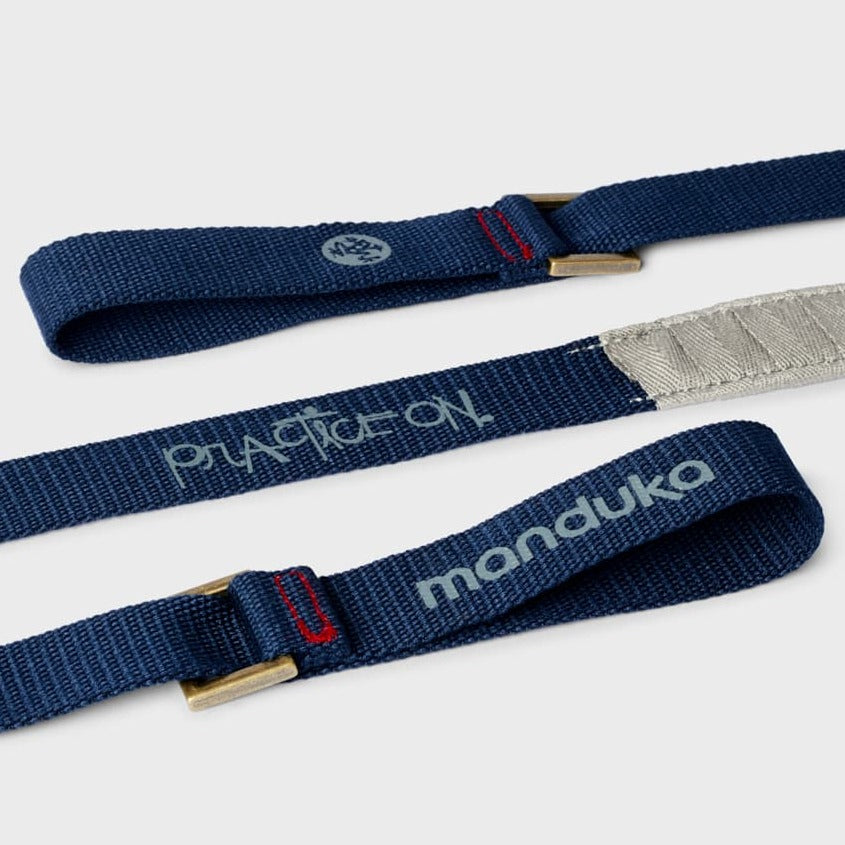 close up of dark blue hoops for yoga mat strap that reads "Practice on" and "manduka"