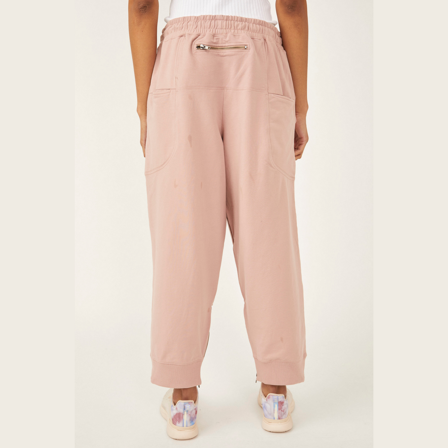 back view of light pink sweat pants with zipper pocked on the top middle
