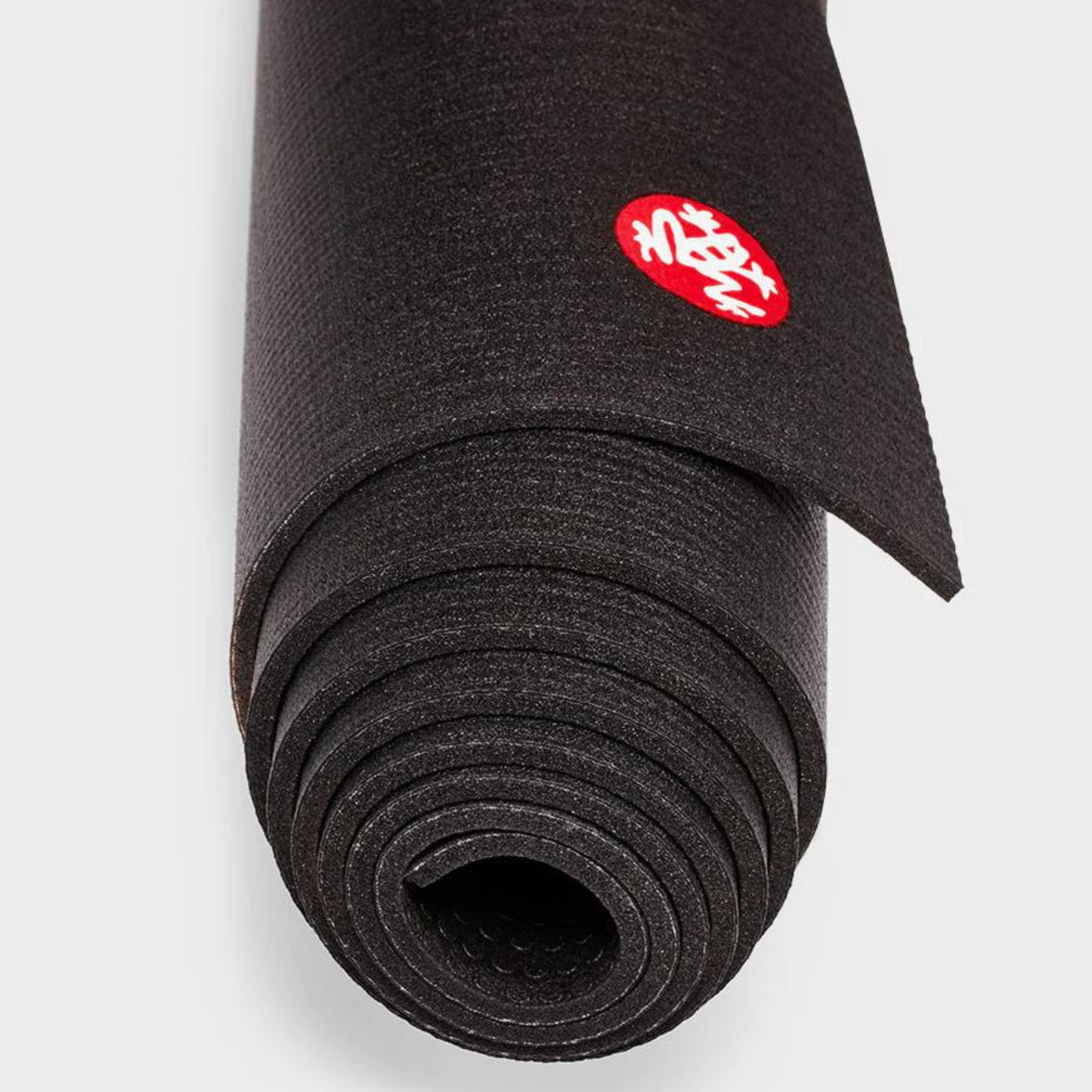 close up of black manduka pro lite yoga mat rolled up
