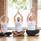 three people sitting with their legs crossed in front of them all wearing person wearing white tee shirts that say  NIPPLE MAFIA written in black surrounded by three people in different yoga poses that form a triangle around the print