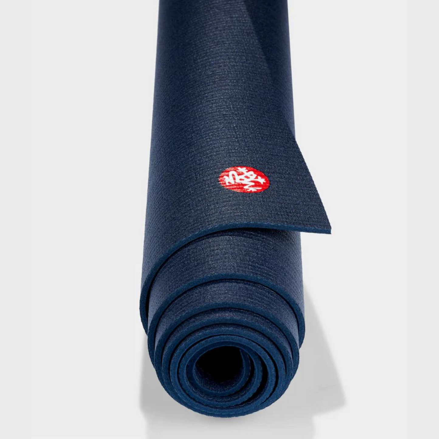close up of navy manduka prolite yoga mat color rolled up